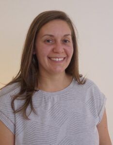 A woman with long hair smiles for the camera.